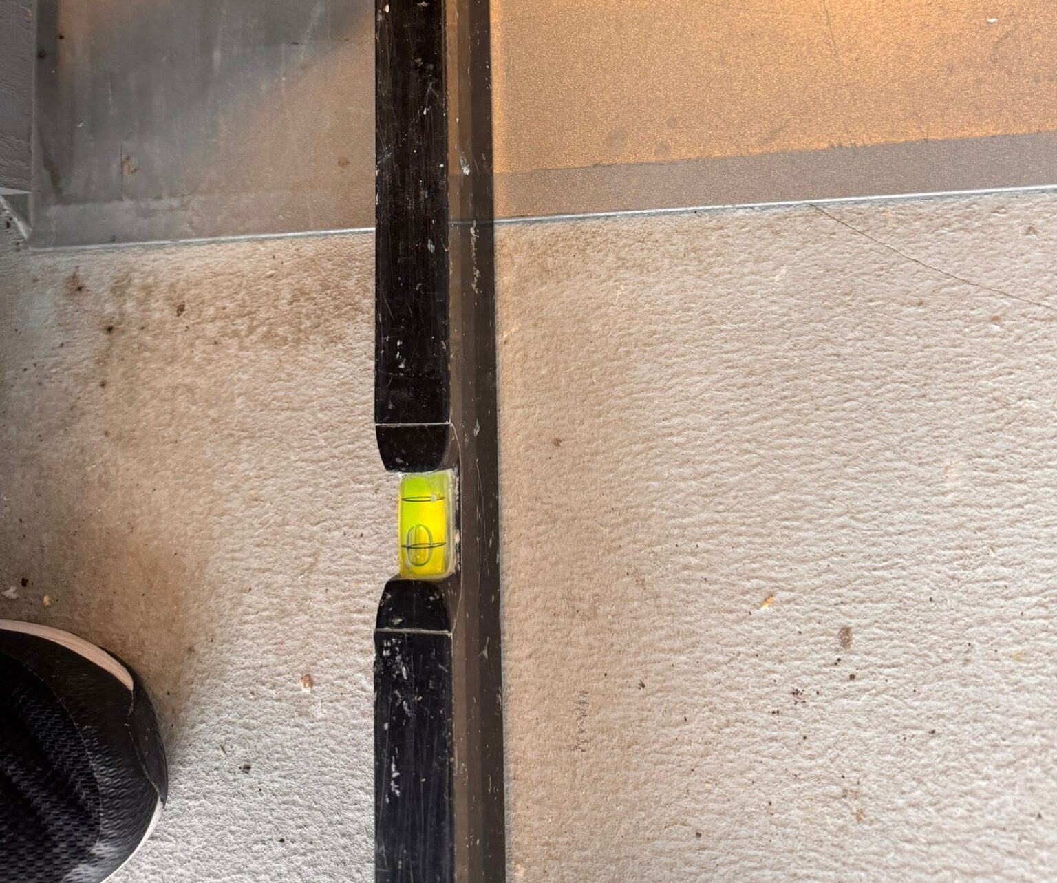 Kontroll av korrekt fall vid justerad balkongdörr och återmonterat underbleck i Knivsta.