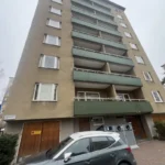 Putsfasad med gröna balkonger på Steningevägen 4 i Årsta före fasadrenoveringen.