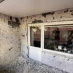 Balkongvägg med nedknackad puts runt fönster och balkongdörr på Steningevägen 4 i Årsta.