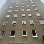 Putsfasad med vita fönsterkarmar på Steningevägen 4 i Årsta före fasadrenoveringen.