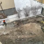 Schaktning med en mindre grävmaskin under innergårdsrenovering hos BRF Kastanjen på Södermalm i Stockholm.