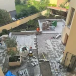 Stenläggning med markplattor runt planteringsytor på BRF Kastanjens innergård på Södermalm, sedd ovanifrån.