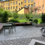 Renoverad innergård med stenläggning, sittplatser och planteringar hos BRF Kastanjen på Södermalm i Stockholm.